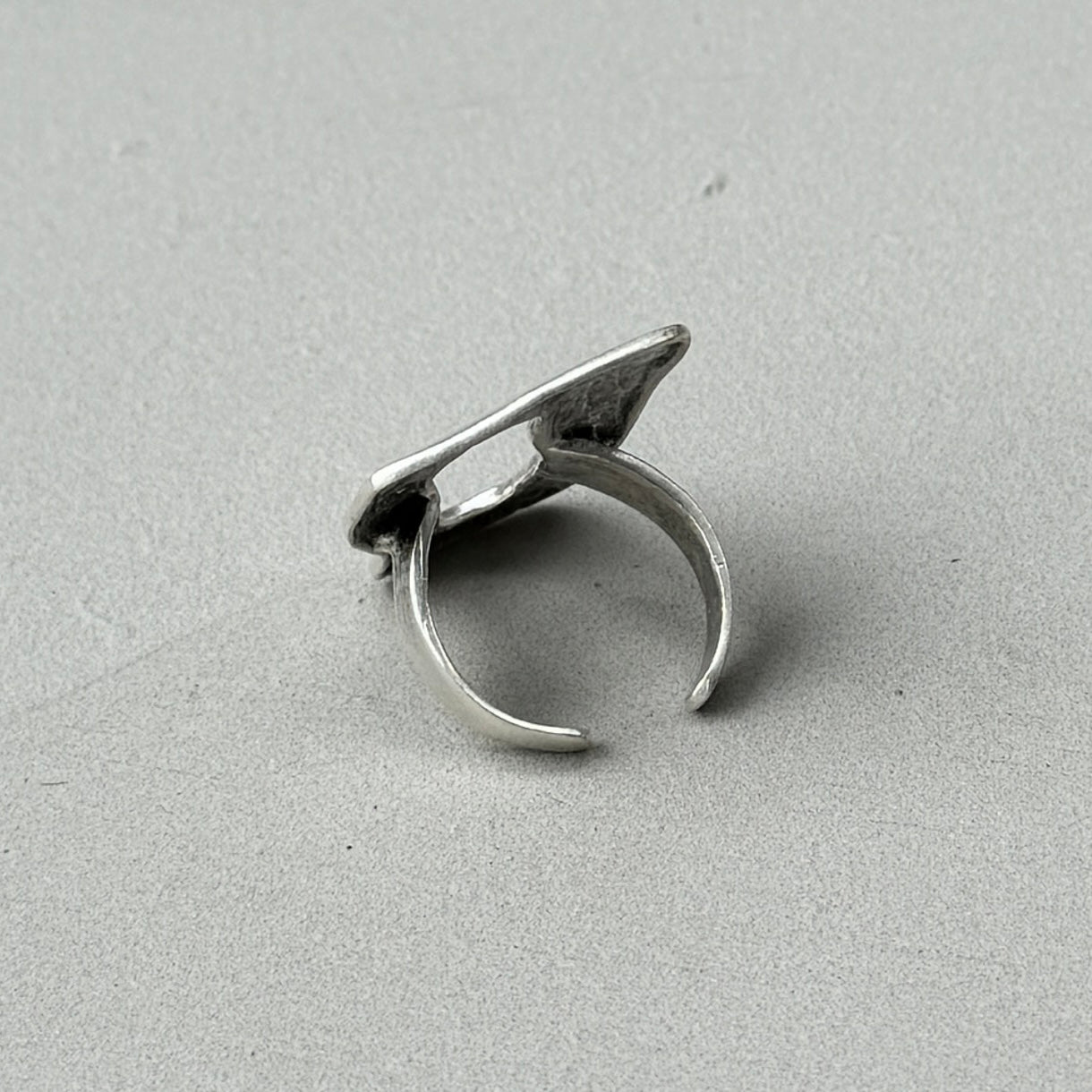 photo of the back of a silver ring with an oversized abstract statement design and vintage silver finish