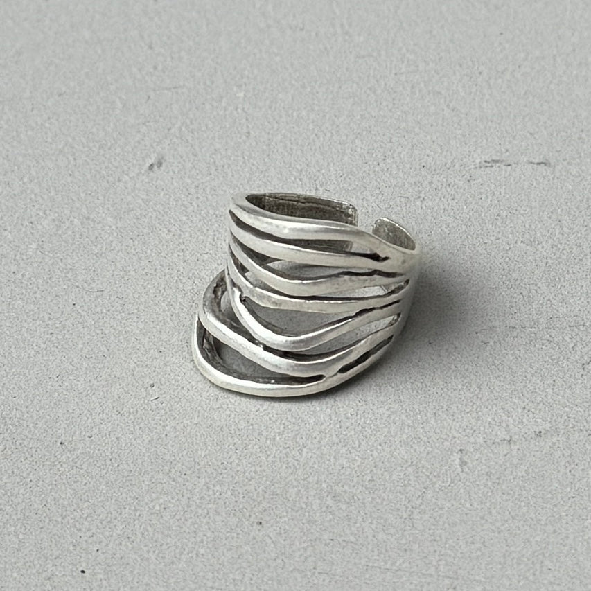 photo of a silver ring with abstract lines and an aged silver finish.