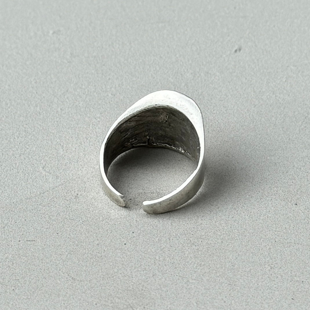 a photo of the back of a silver ring with an oversized asymmetric abstract style and vintage silver finish