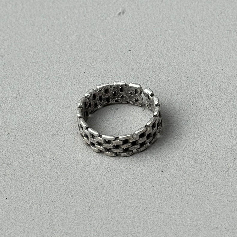 photo of a silver ring with a chain link design