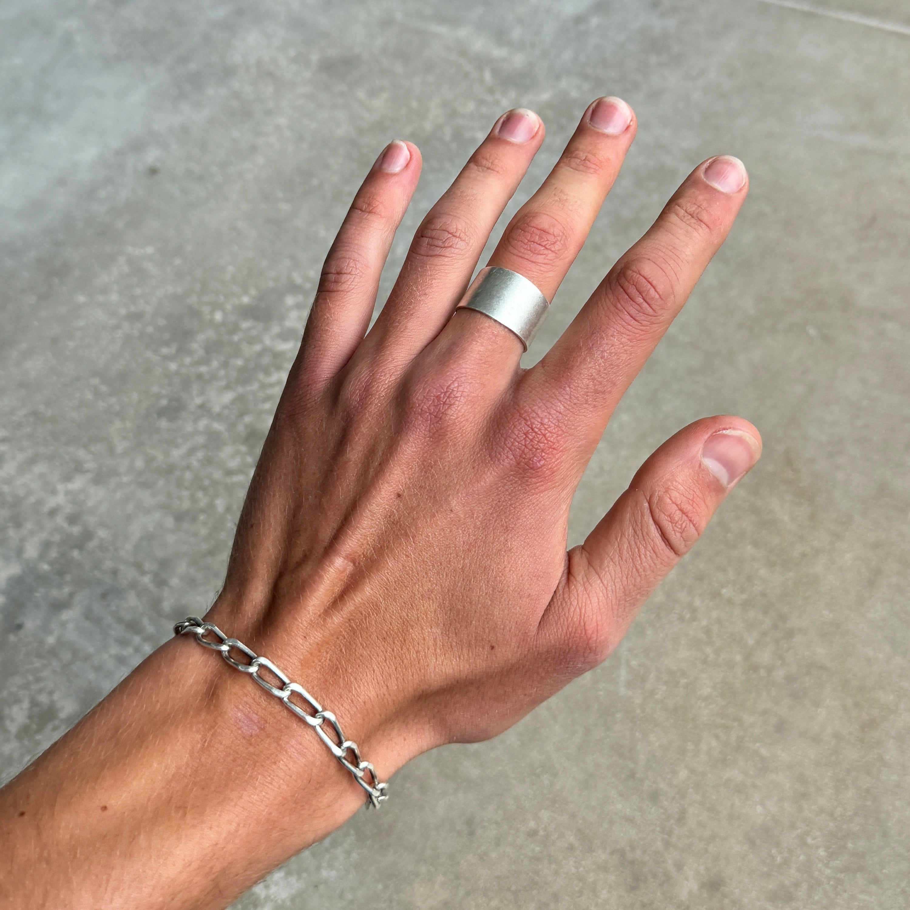 photo of a hand wearing a simple silver band ring