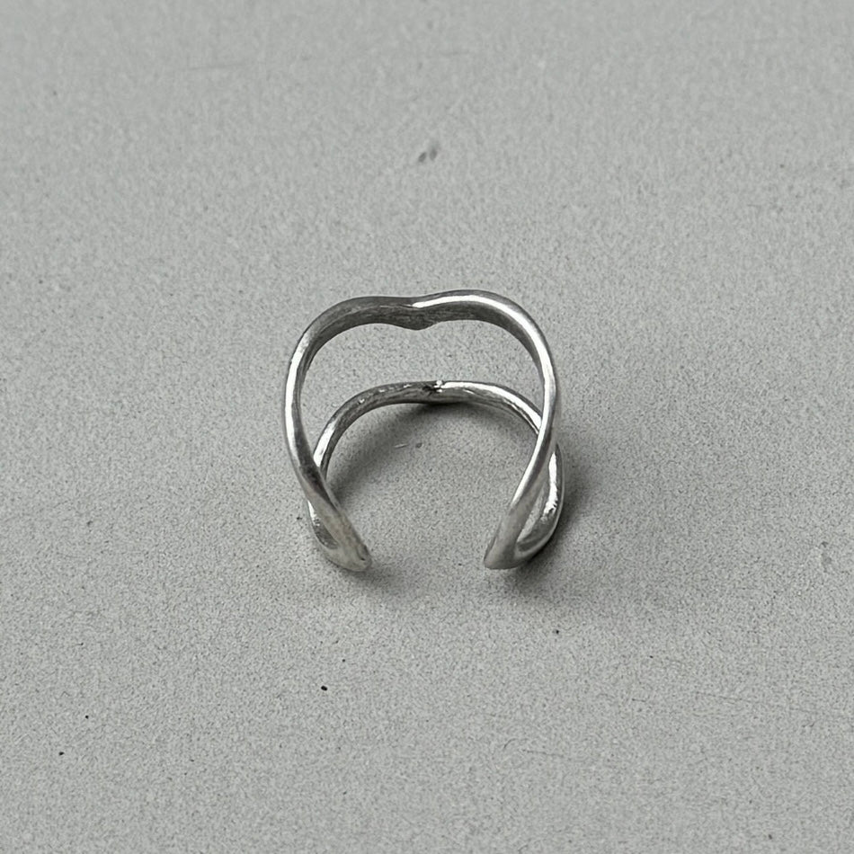 photo of the back of a silver ring with a minimalist double arrow design