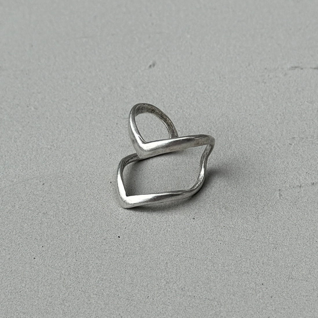 photo of a silver ring with a minimalist double arrow design