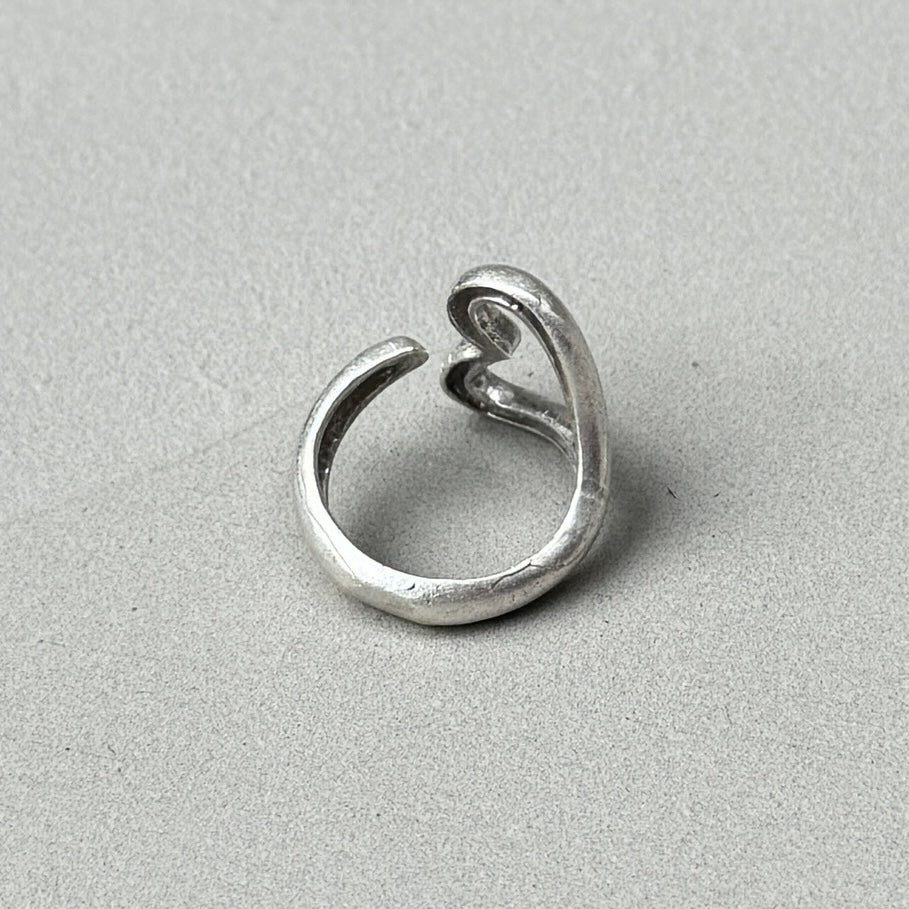 photo of the back of a minimalist heart elsa peretti style silver ring