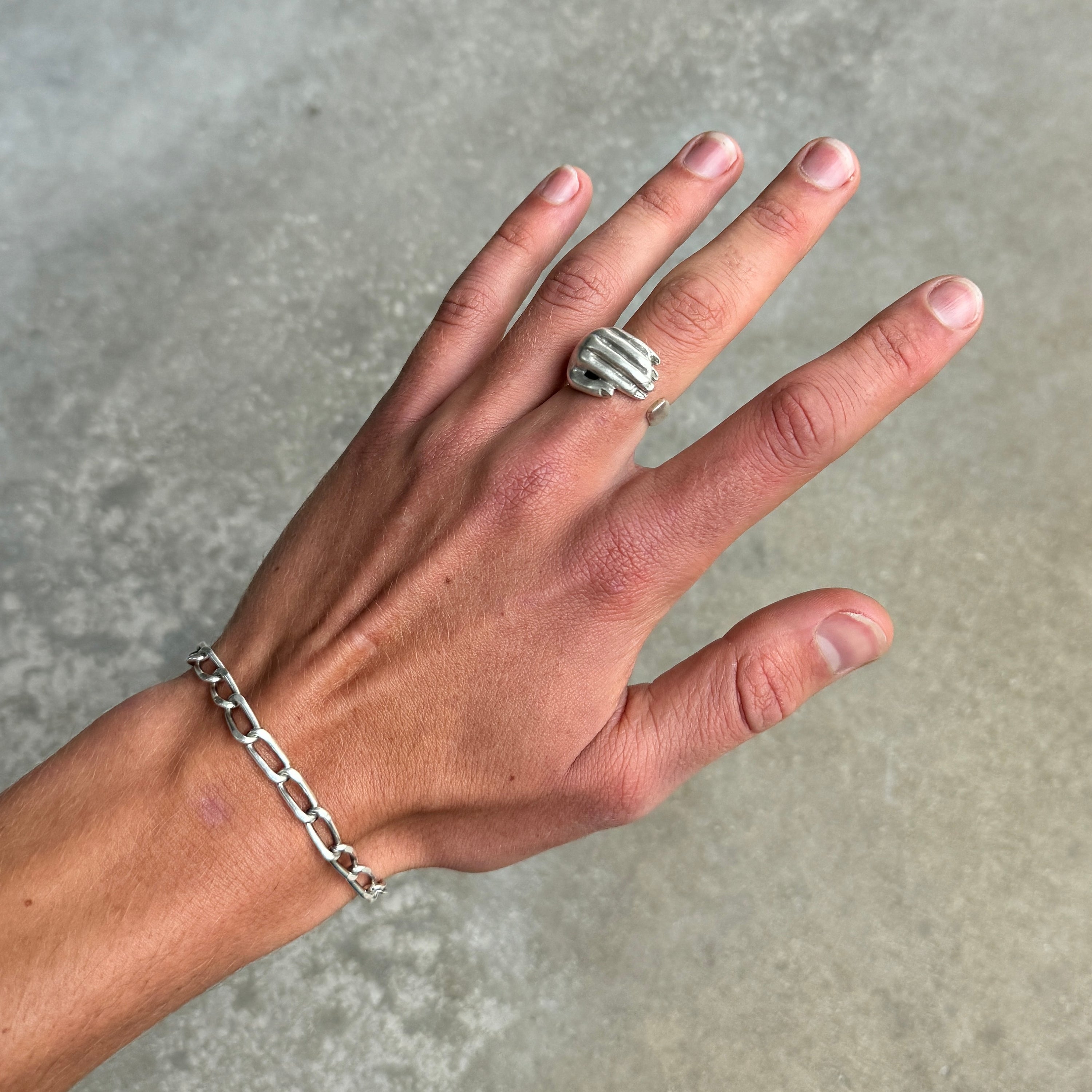 cupped hand shaped silver ring with a vintage oxidised silver finish on a hand
