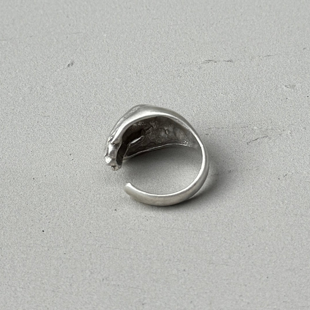 the back of a cupped hand shaped silver ring with a vintage oxidised silver finish
