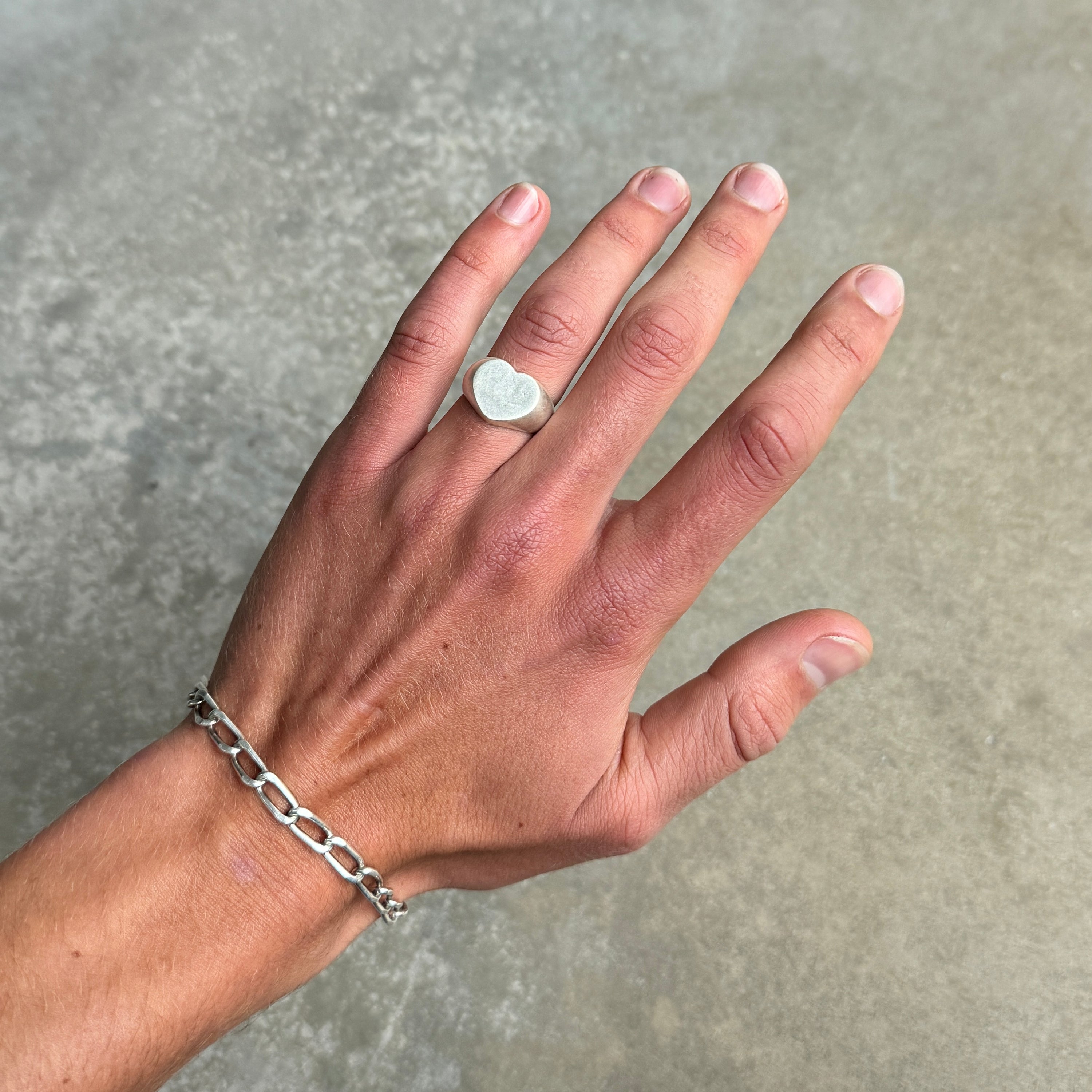 heart shaped silver ring on a hand.