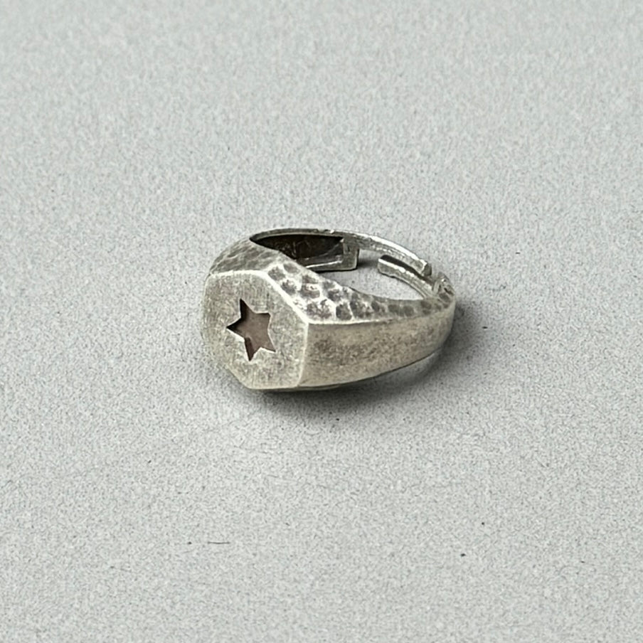 photo of a silver signet ring with a star design engraved on the front