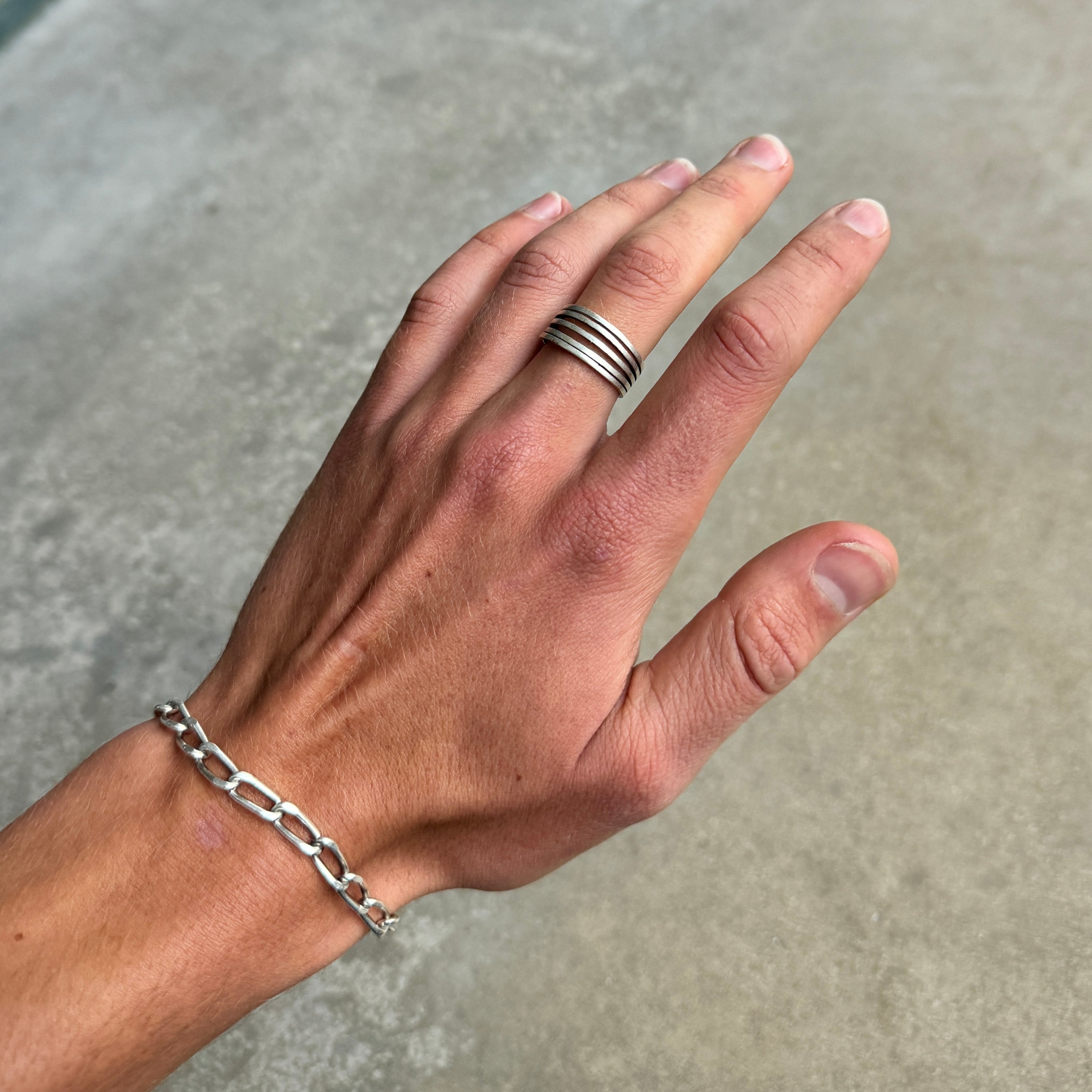 photo of a vintage looking silver ring with 5 lines on a hand