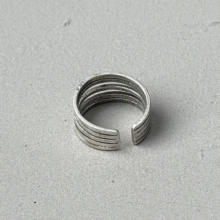 photo of the back of a vintage looking silver ring with 5 lines