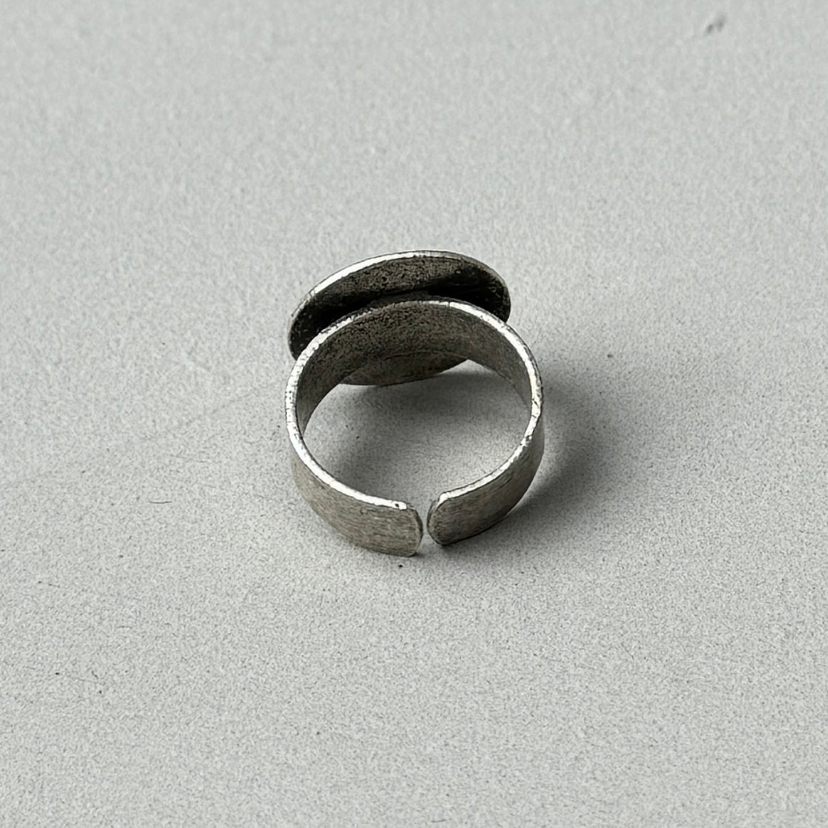 photo of the back of a silver ring with an oversized circle design and antique style finish to the silver