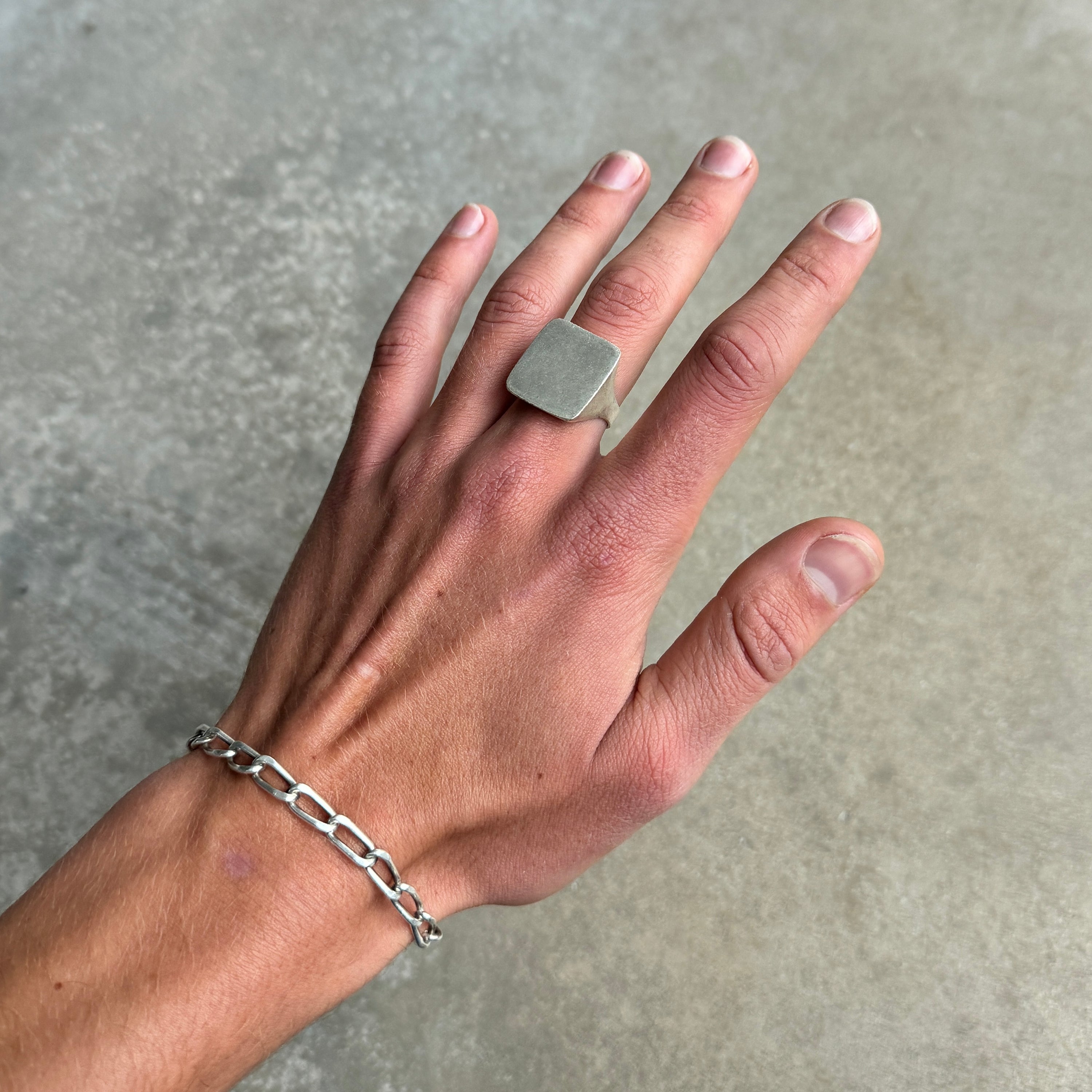 minimalist large square silver ring on a hand