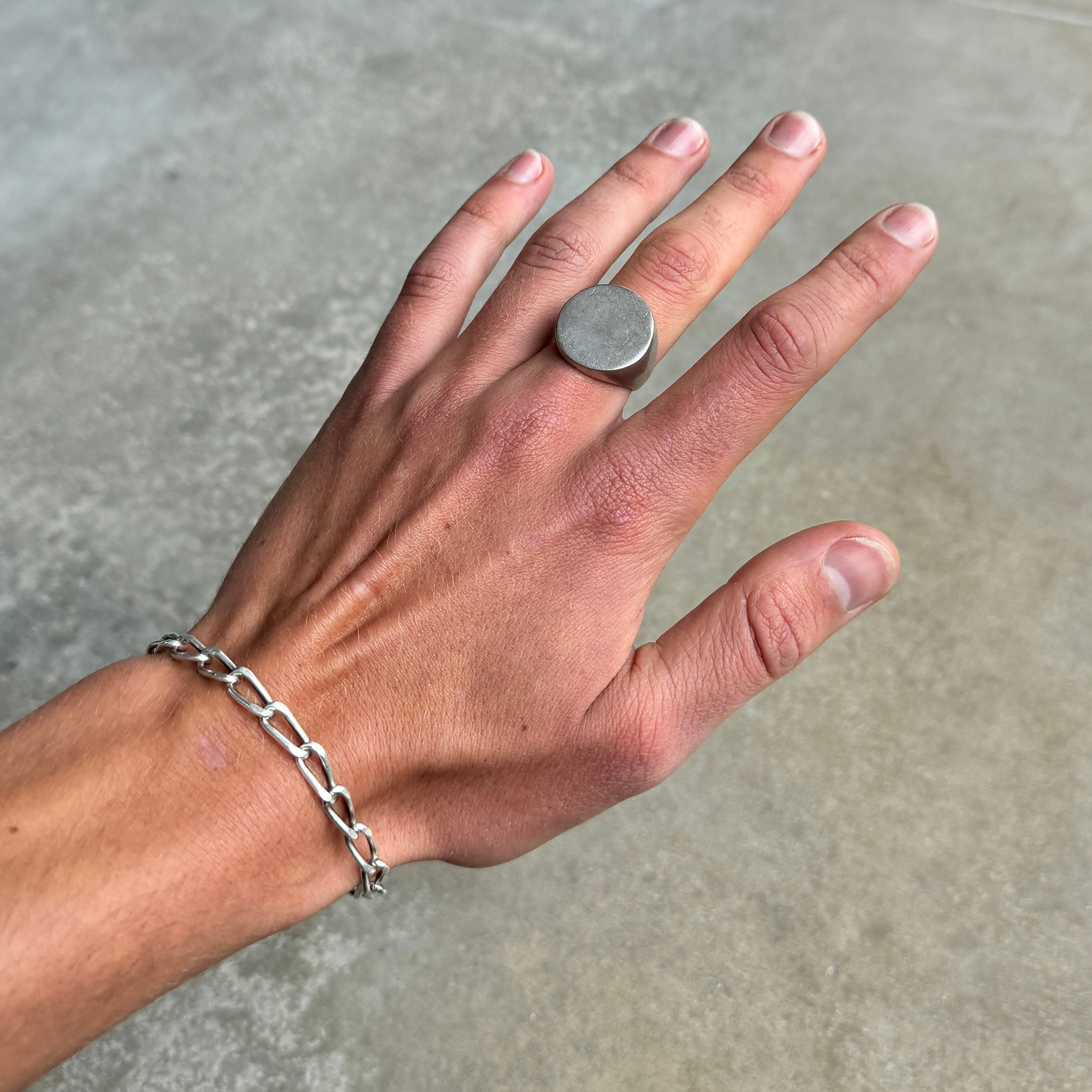 photo of a circle silver signet ring on a hand