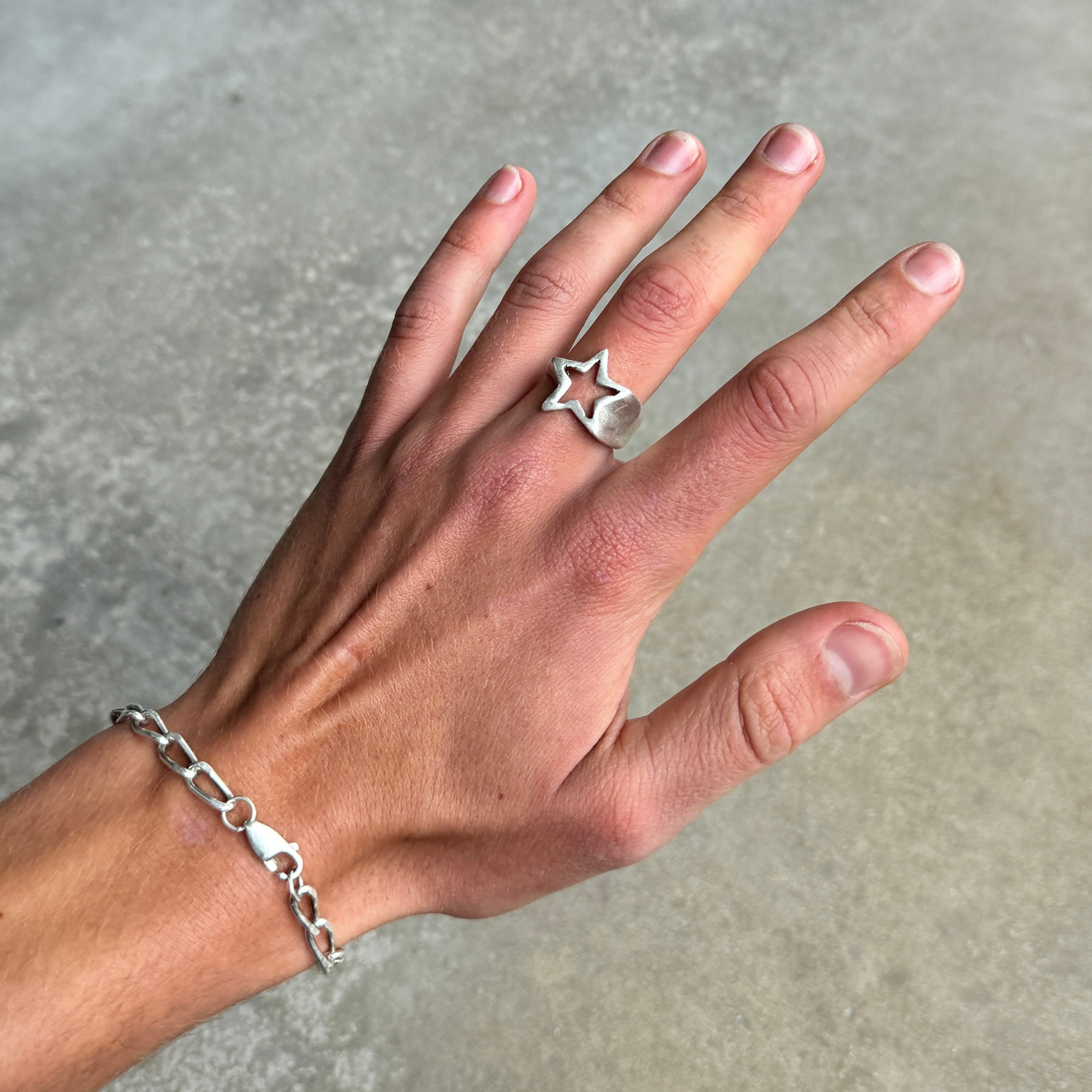 photo of a hand wearing a silver ring with a shooting star design and vintage silver finish.