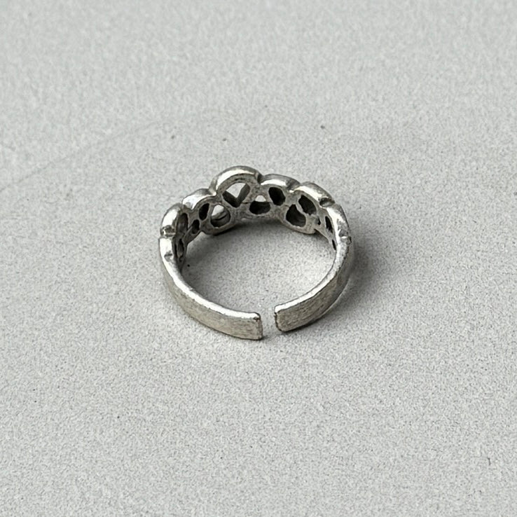 photo of the back of a silver ring with a squiggle line design