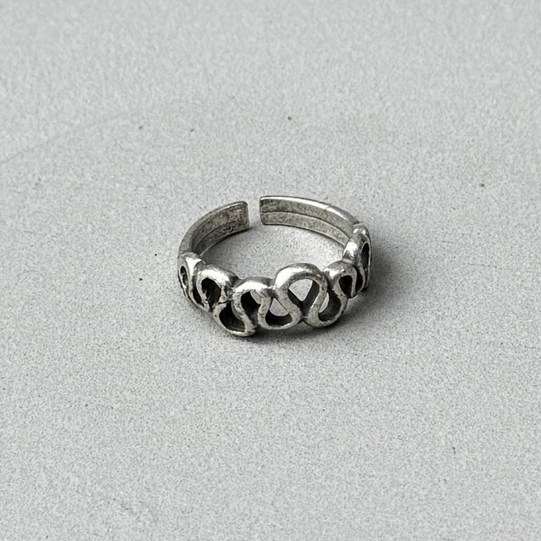 photo of a silver ring with a squiggle line design