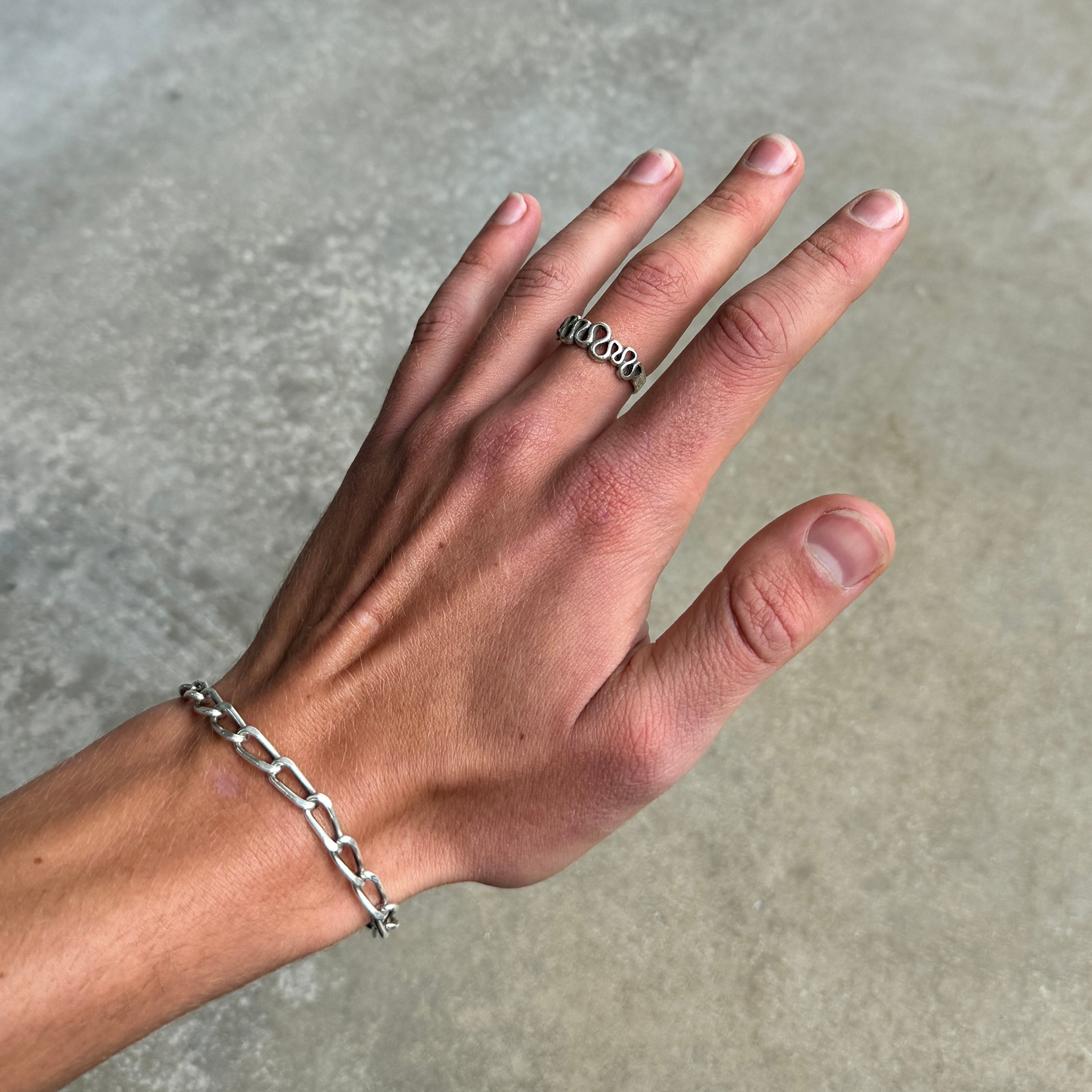 photo of a hand wearing a squiggle silver ring