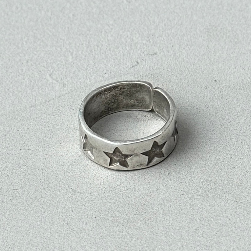 a photo of a silver ring with a stamped star design and vintage silver finish